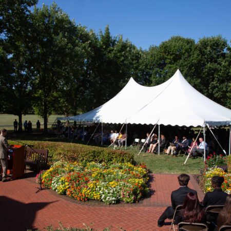 a white tent with people sitting in chairs