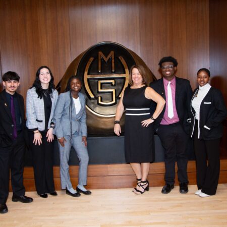 a group of people standing in front of a logo