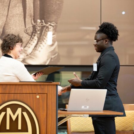 a person standing at a desk with a laptop