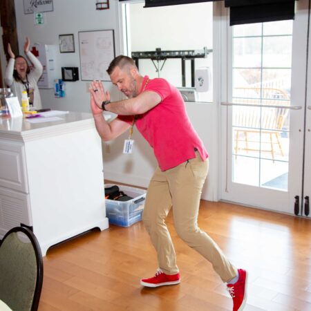 a person in a pink shirt and khaki pants playing a video game