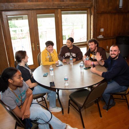 a group of people sitting around a round table