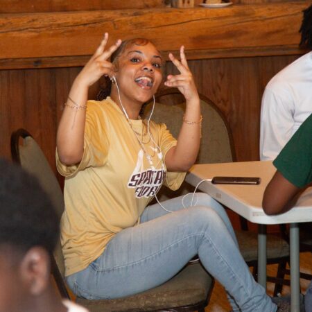 a person sitting in a chair with her hands up