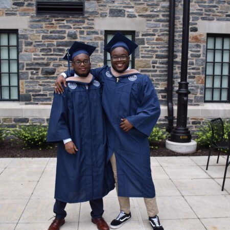 two men in graduation gowns and cap and gowns
