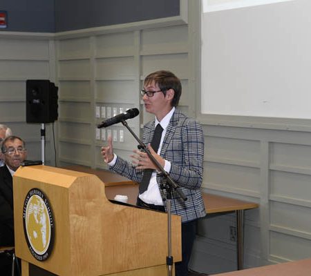 a person standing at a podium with a microphone