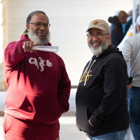 two men standing together smiling