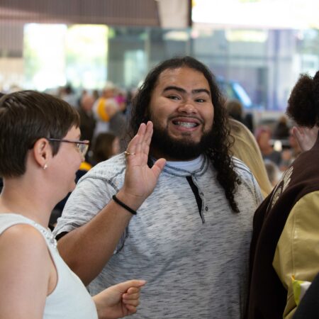 a person waving his hand to another person