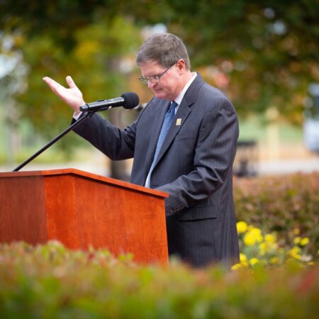 a person standing at a podium with a microphone