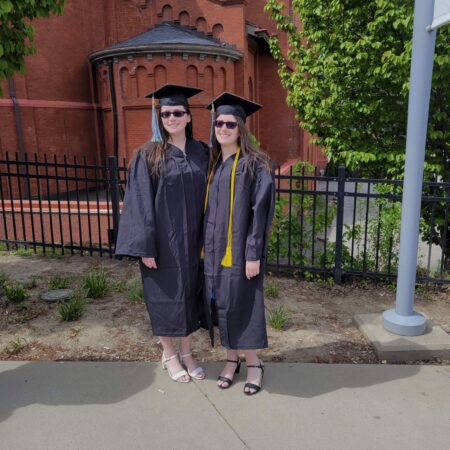 two women in graduation gowns and cap and gowns